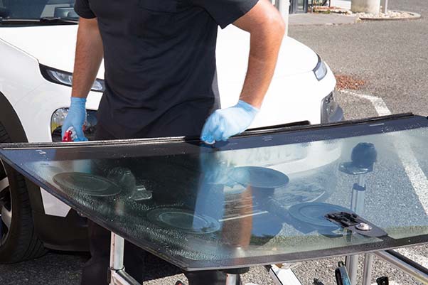 Glazier removing windshield or windscreen on a car