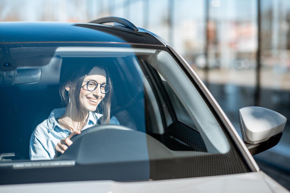 happy woman driving a car front windshield Sedona, AZ