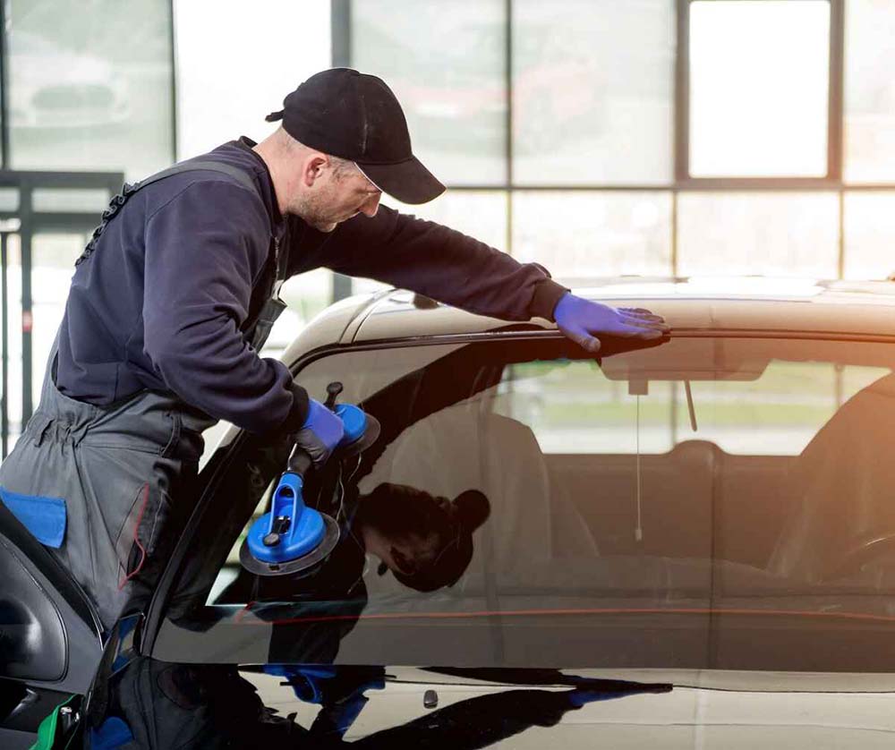 car mechanic looking at chipped windshield